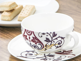 Empty coffee cup and biscuits