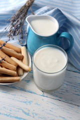 Obraz na płótnie Canvas Homemade yogurt in jug and tasty sweet bread sticks