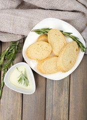 Fresh bread with olive oil and rosemary on wooden table