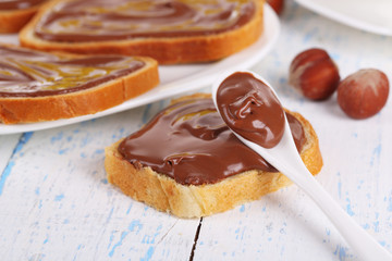 Bread with sweet chocolate hazelnut spread on plate on table