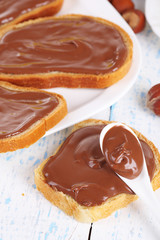 Bread with sweet chocolate hazelnut spread on plate on table