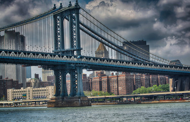 Side view of Manhattan Bridge structure and New York buildings