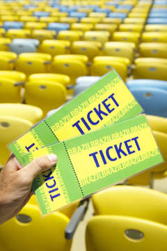 Soccer Fan Holding Two Brazil Tickets at Stadium