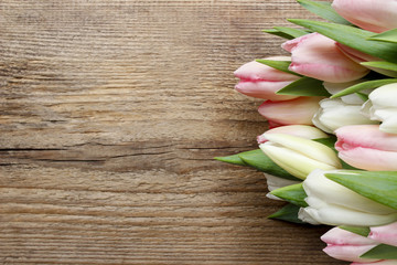 Beautiful pink and white tulips on wooden background. Copy space