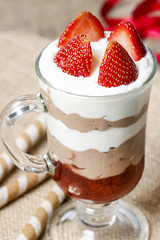 Layer strawberry and chocolate dessert in glass goblet