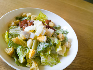 caesar salad placed on top of a wooden table