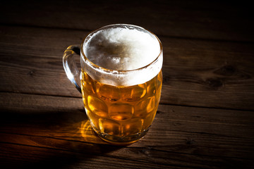 Mug of beer on wooden background