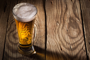 Mug of beer on wooden background