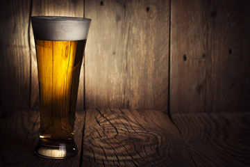 Mug of beer on wooden background