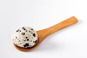 Quail eggs in a wooden spoon isolated on white