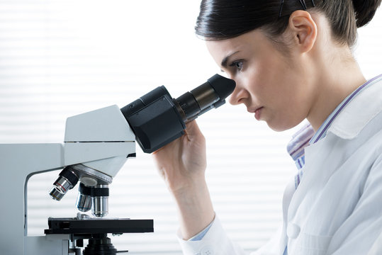 Female researcher using microscope