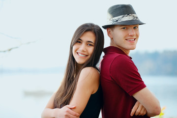 Obraz premium Beautiful young interracial couple standing back to back