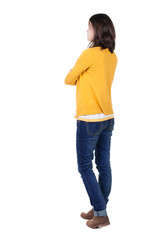 back view of standing young beautiful  brunette woman in yellow