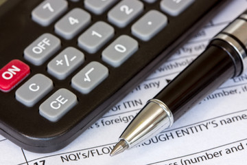 Tax form with pen and calculator