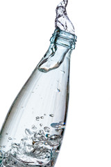 Glass bottle splashing water isolated on white