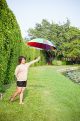 Asian woman holding an umbrella in the park.