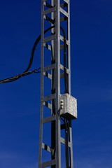 High voltage tower with blue sky behind