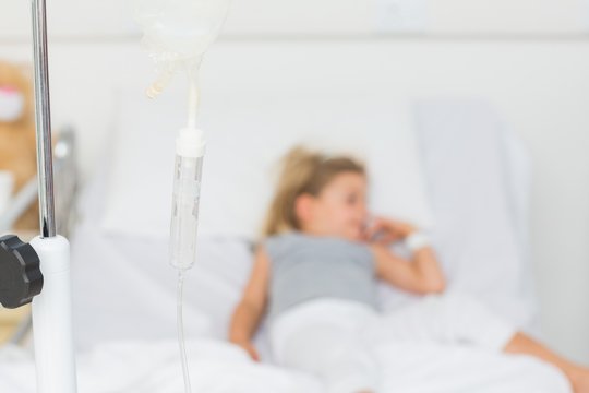 IV Drip With Sick Girl In Hospital Bed