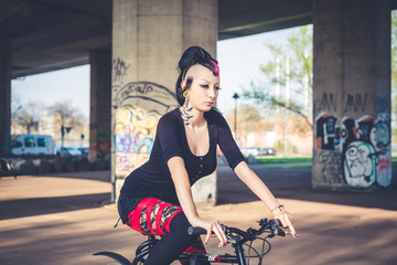 young beautiful punk dark girl riding bike