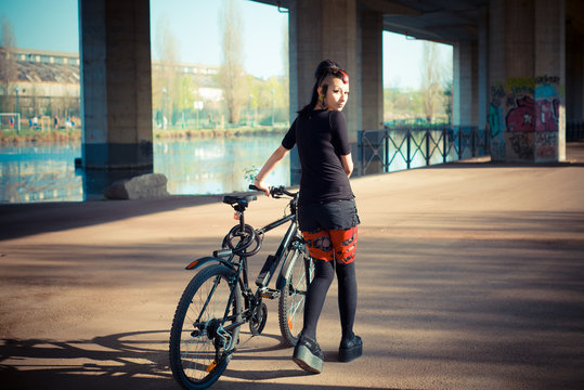 Young Beautiful Punk Dark Girl Riding Bike