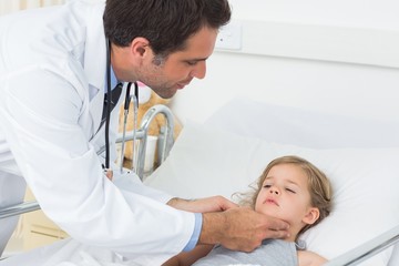 Obraz premium Doctor checking thyroid glands of sick girl