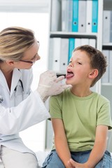 Fototapeta premium Doctor looking at the mouth of boy