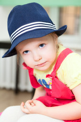 Portrait of little Caucasian girl in blue hat