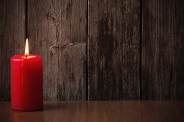 Fototapeta na wymiar red candle on wooden background