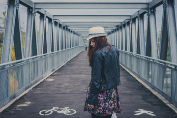 Pretty girl walking away on a bridge
