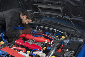 Car repairman examining modified rally car