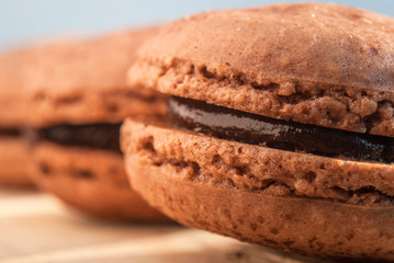 Chocolate flavor Macaroon placed on wood and leather