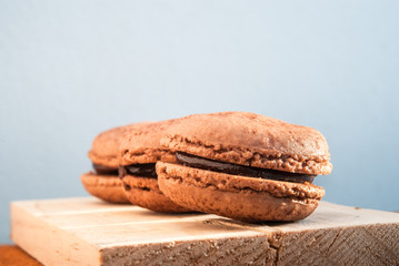 Chocolate flavor Macaroon placed on wood and leather