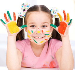 Portrait of a cute girl playing with paints