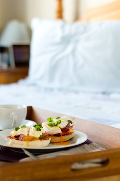 Eggs Benedict on breakfast tray on bed