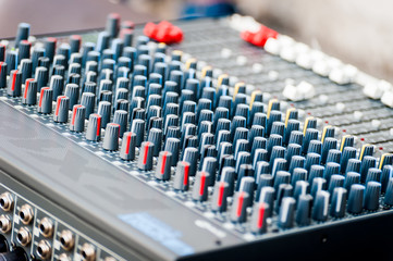 Close-up of sound mixer control panel with many controls