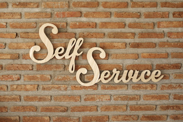 wood die cutting self-service sign on red brick wall