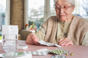 Elderly woman with pills - obrazy, fototapety, plakaty