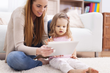 Focus woman with little girl using digital tablet