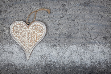 carved wooden heart on grey limestone background