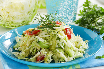 Young cabbage salad with cucumbers and tomatoes.