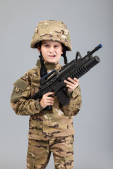 Young boy dressed like a soldier with rifle
