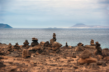 stone piles in playa blanca with fuerteventura in background