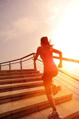 Fotobehang fitness young asian woman running sunrise seaside stairs © lzf