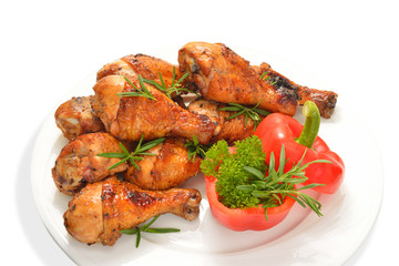 Grilled chicken legs with vegetables isolated on white.