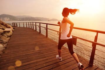 Fototapeta premium fitness young asian woman running sunrise seaside