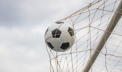 Soccer football in goal net