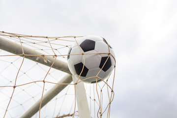 Soccer football in goal net