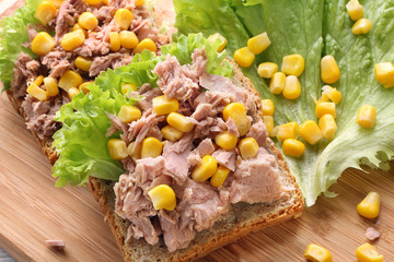 Sandwich with tuna and corn on wood