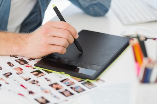 Designer working with graphics tablet at his desk