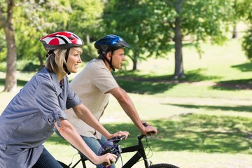 Fototapeta na wymiar Happy couple cycling in park